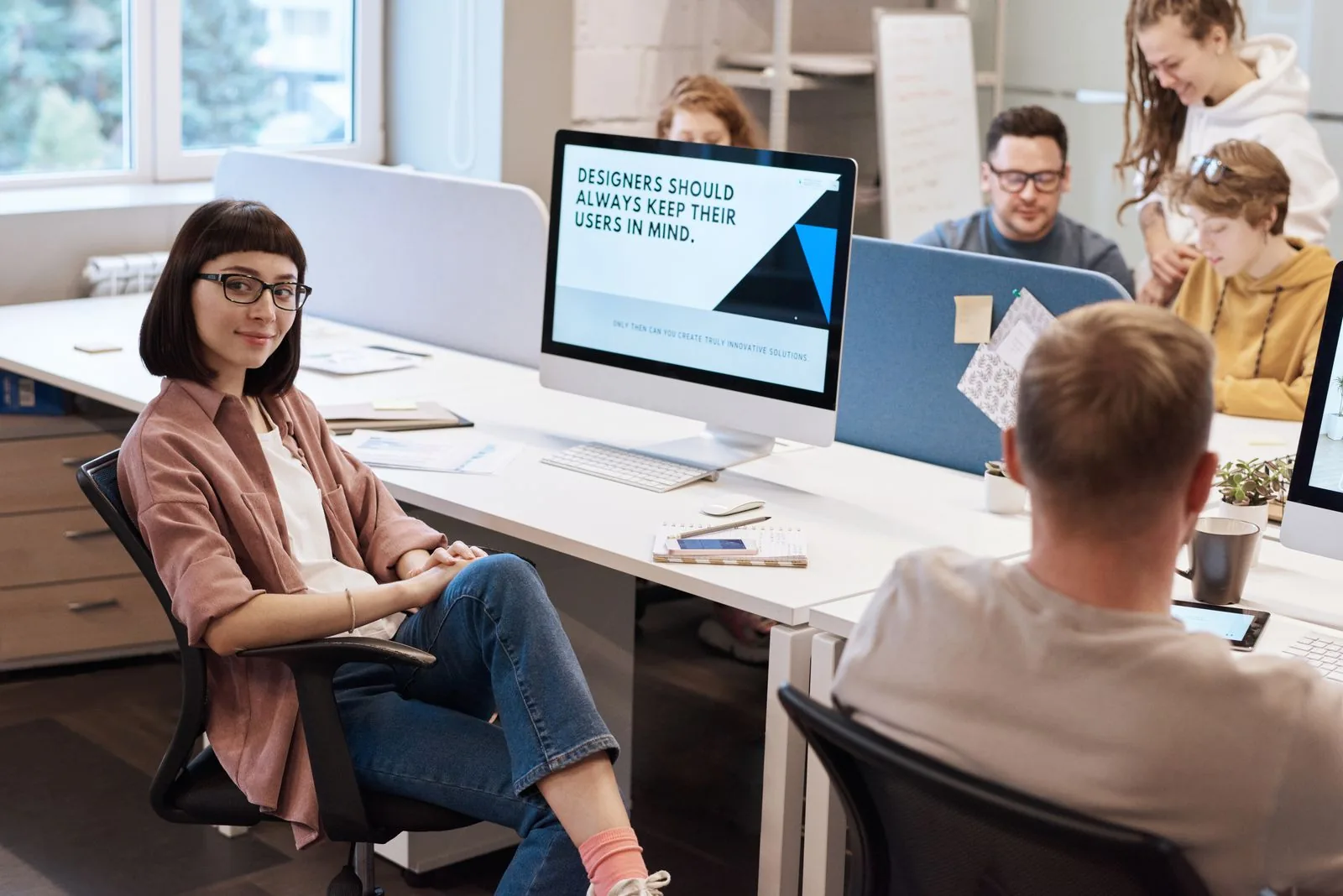 Squadra di giovani professionisti che collaborano in un ufficio moderno, promuovendo creatività e innovazione.